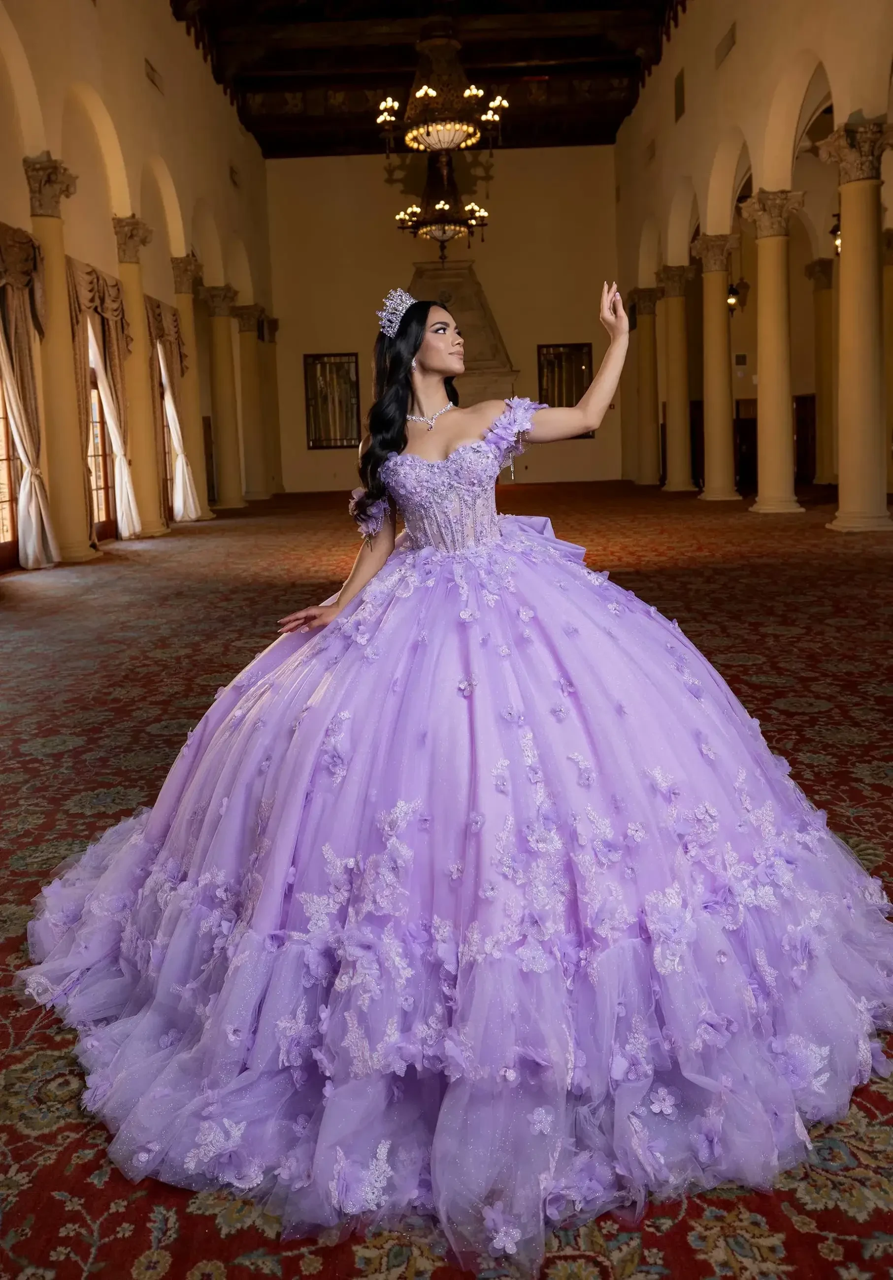 A young woman stands gracefully in an ornate hall, wearing a stunning lilac ball gown with floral details and a crown, evoking a regal and elegant tone.