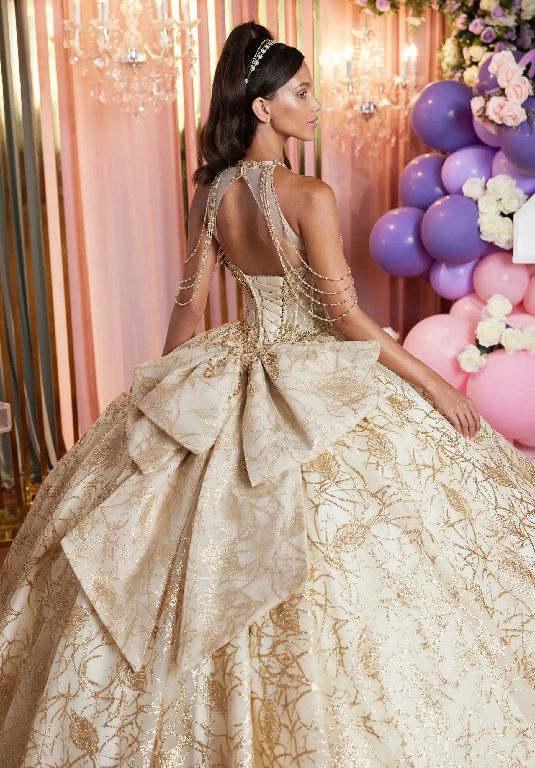 Model is wearing a bold glittery quinceanera ball gown with embellished appliques and tulle