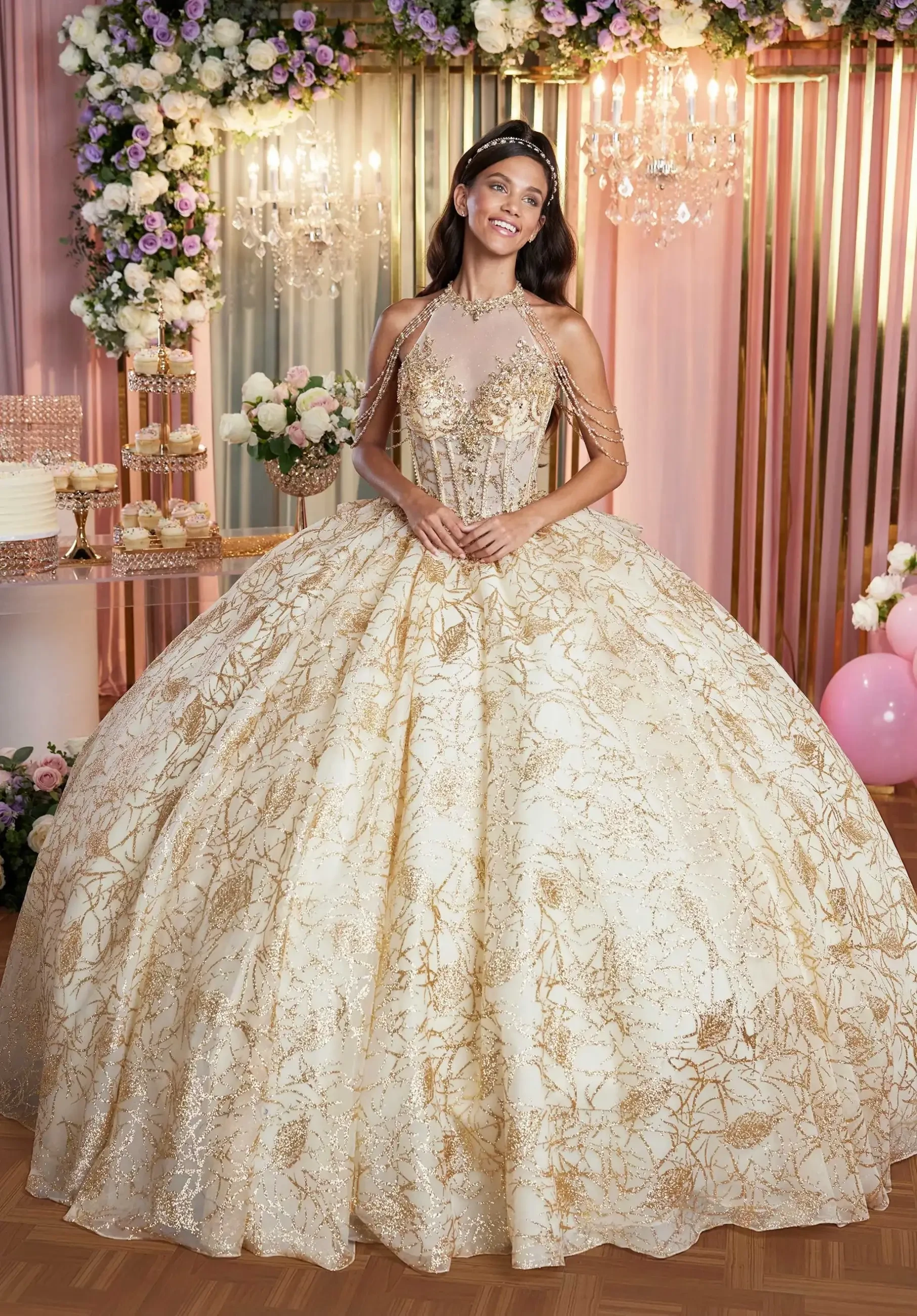 Model is wearing a bold glittery quinceanera ball gown with embellished appliques and tulle