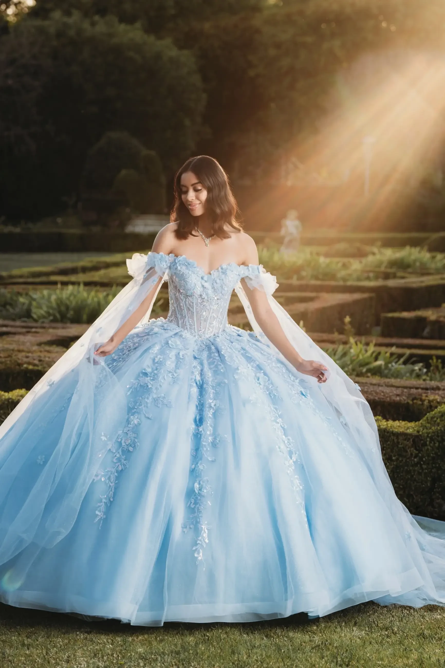 model is wearing a light blue quinceanera gown from amabella