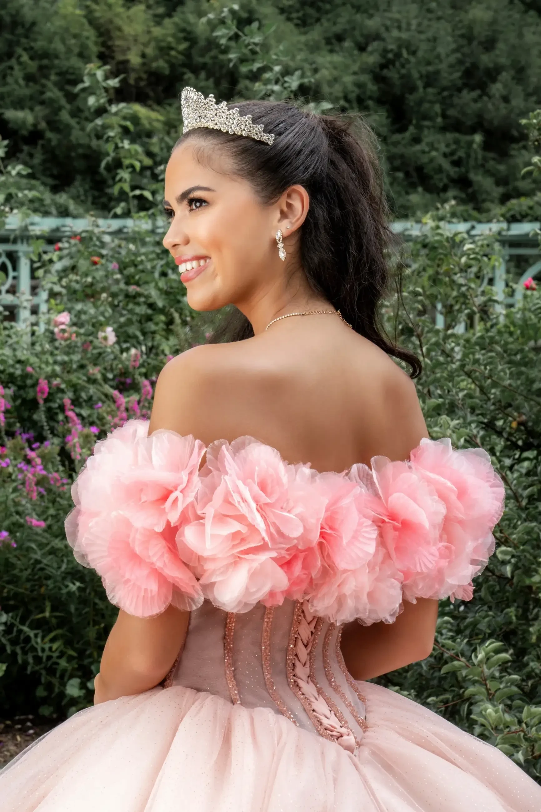 Model is wearing a quinceanera gown with a crystal beaded bodice and a floral store for added glamour