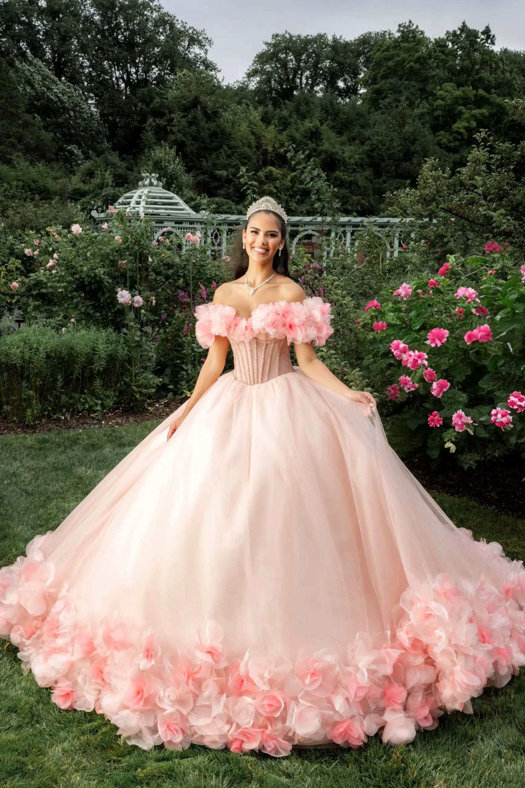 Model is wearing a quinceanera gown with a crystal beaded bodice and a floral store for added glamour