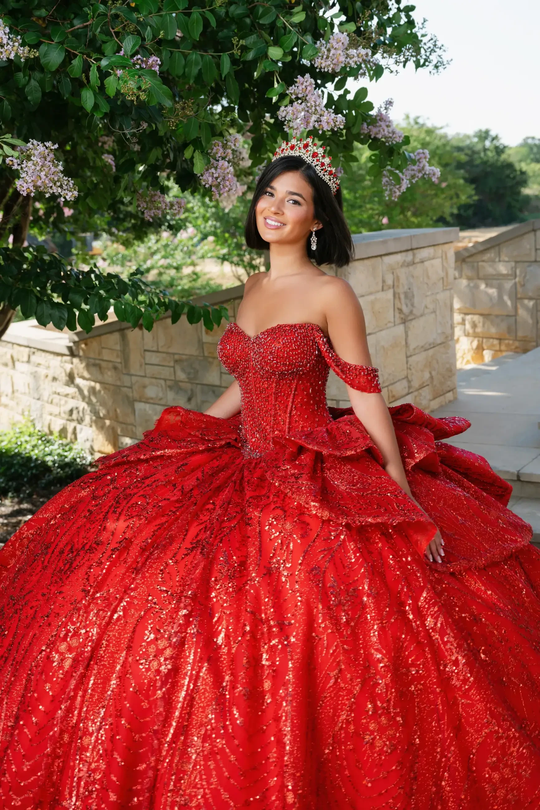 model is wearing an off the shoulder red quinceanera dress